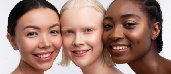 Three smiling women with glowing skin